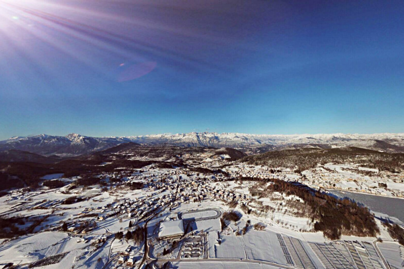 Vista dall'alto di Baselga di Pinè con al centro lo stadio del ghiaccio Ice Rink
